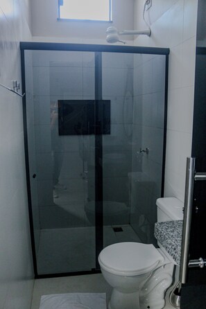 Een douche, handdoeken, zeep, toiletpapier