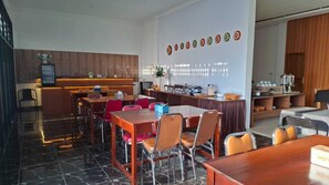 A hotel lobby with a reception desk, seating area, and a wall with circular decorations. - ACO BORNEO HOTEL (Malinau)