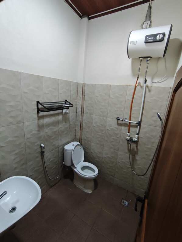 A bathroom with a toilet, a sink, a shower, and a water heater.