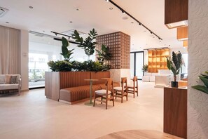A modern interior with a seating area, a wooden partition with plants, and a bright, well-lit space. - Majestic 2-Bed Pool Access Ocean View by Bocobay (Willemstad)