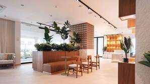 A modern interior with a seating area, a wooden partition with plants, and a bright, well-lit space. - Majestic 2-Bed Pool Access Suite by Bocobay (Willemstad)