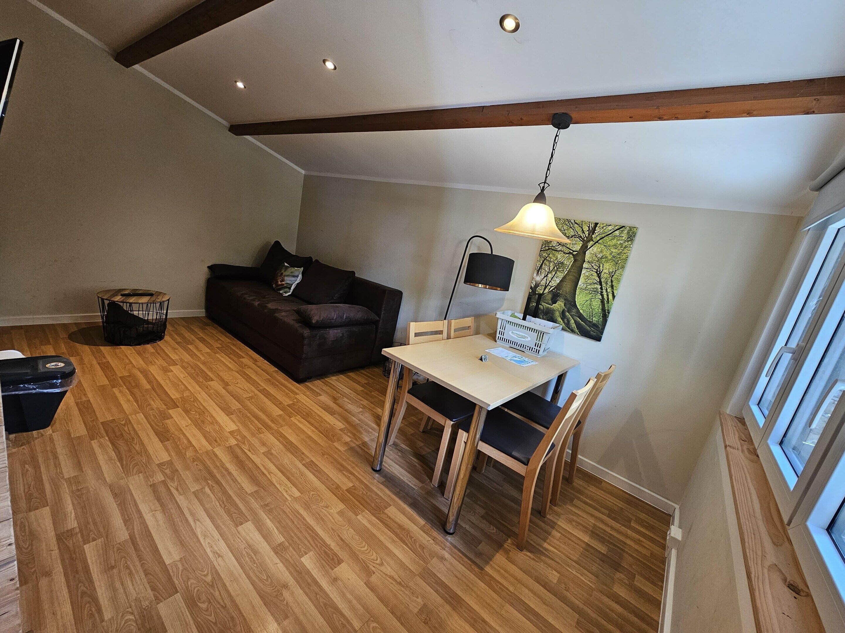 A cozy living area with a sofa, a dining table, and a lamp.