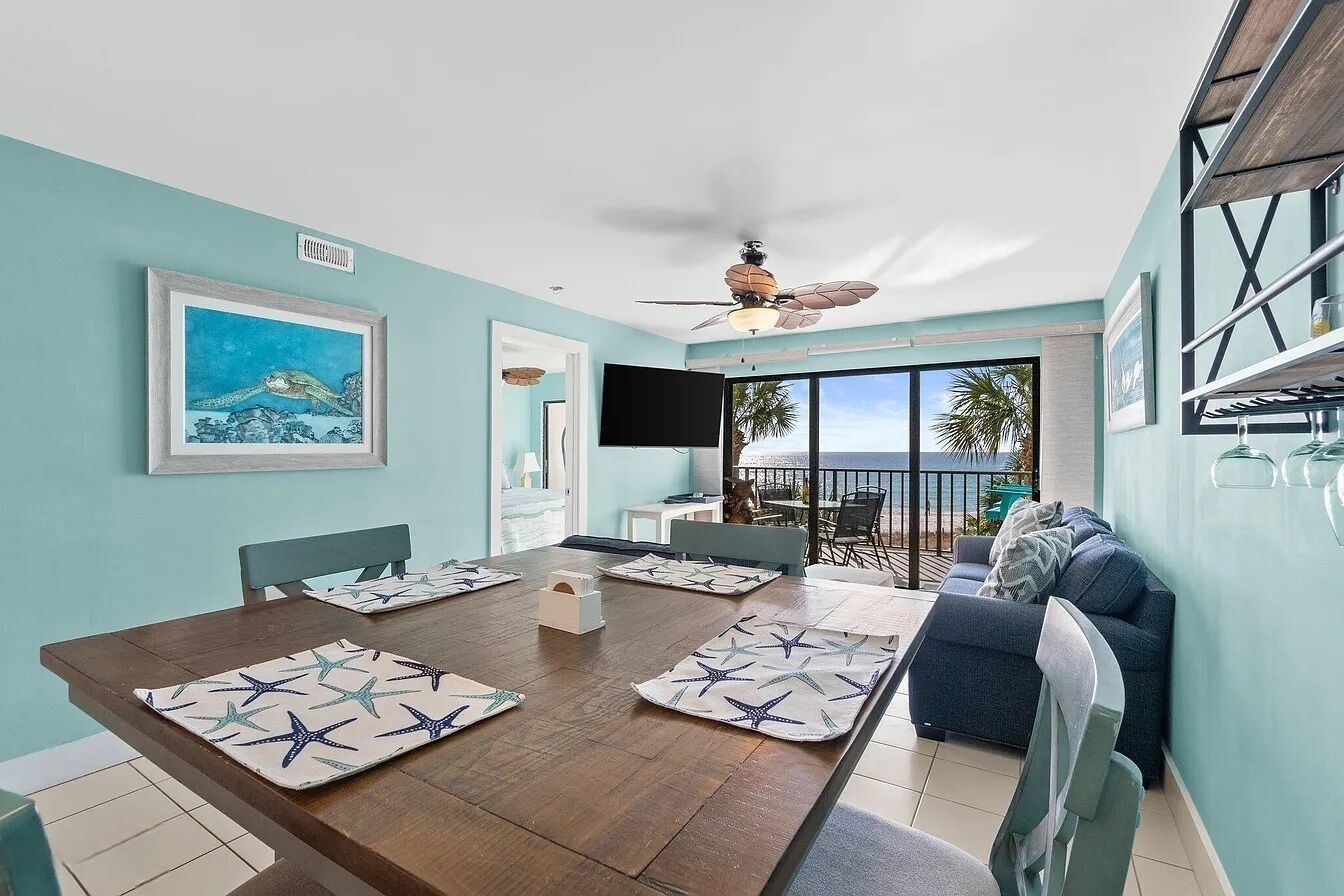 A dining area with a wooden table, star-patterned placemats, and a ceiling fan.