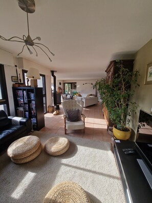 A living room with a sofa, armchairs, a coffee table, a bookshelf, a TV, and a potted plant. - Family home ideal for 3 families (sleeps 14) (Saint-Jorioz)