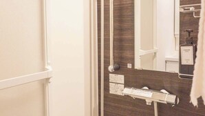 Ein Badezimmer mit Dusche, Toilette und Spiegel.