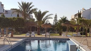 A rectangular swimming pool with metal railings, surrounded by lounge chairs and palm trees. - Perfect Getaway in Vera With Terrace (Vera)