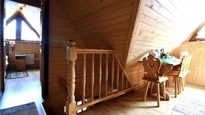 A wooden interior with a dining area, a staircase, and a view of the outside. - Pokoje Gościnne Majerczyk  (Zakopane)
