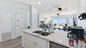 Una cocina moderna con una isla grande, pileta doble y electrodomésticos integrados.