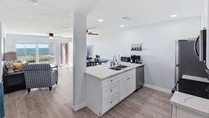 Una cocina moderna con armarios blancos, estufa integrada y vistas al exterior.
