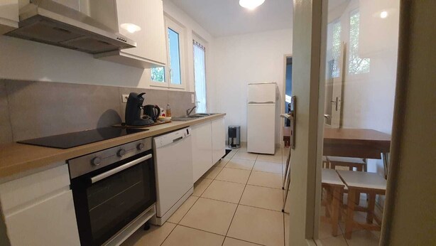 A modern kitchen with a stove, oven, dishwasher, and a refrigerator. - Vacation home on the Bay of Arcachon (La Teste-de-Buch)