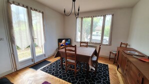 A dining area with a table, chairs, a chandelier, and a television. - Vacation home on the Bay of Arcachon (La Teste-de-Buch)