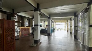 A spacious corridor with a high ceiling, fans, and a hanging light fixture. - Hickory Penang Hill (George Town)