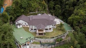 A large, multi-story house with a green roof, surrounded by dense forest. - Hickory Penang Hill (George Town)