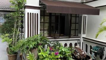 A building with a covered entrance, potted plants, and a water feature.