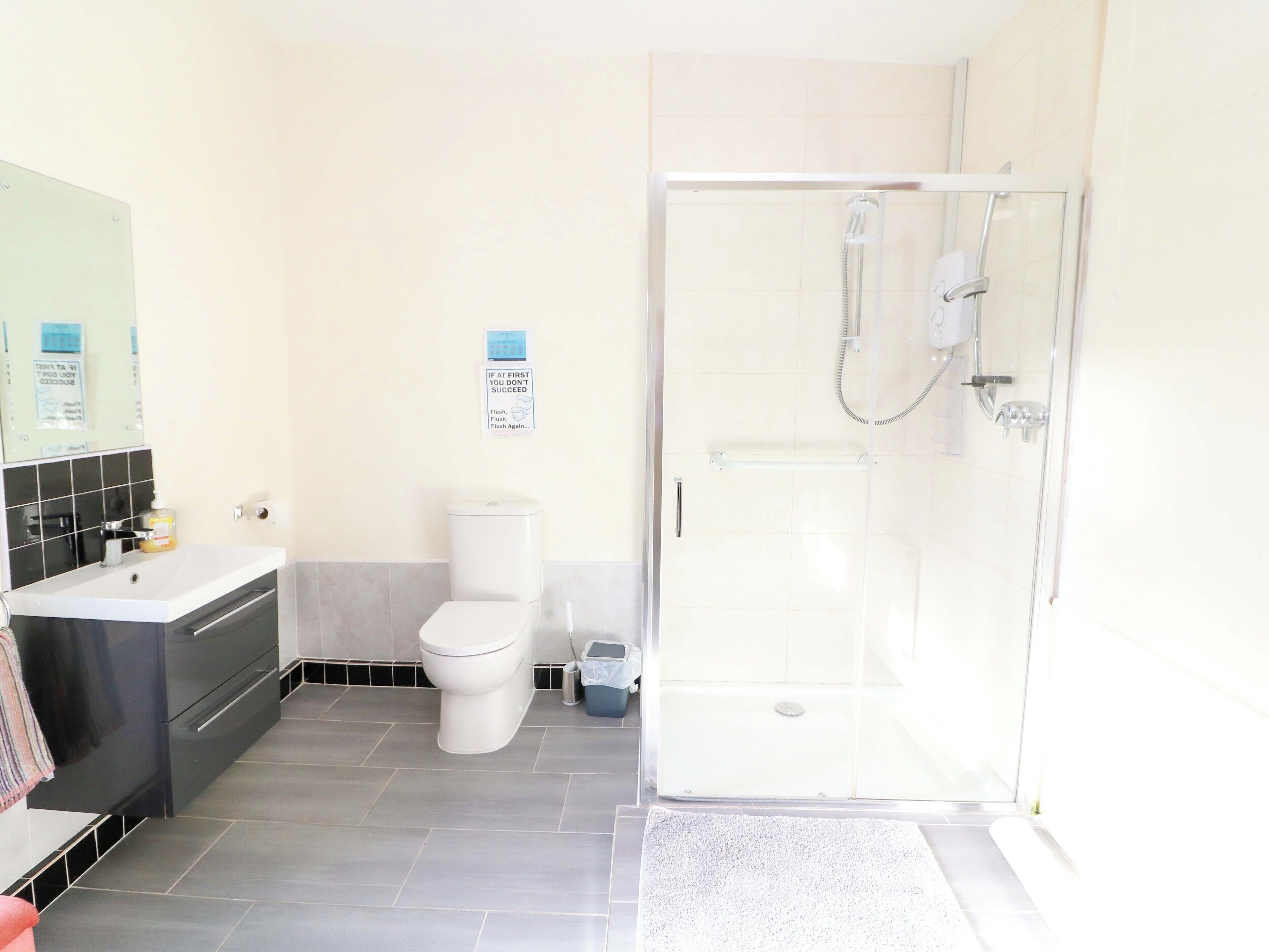A bathroom with a toilet, sink, and shower.