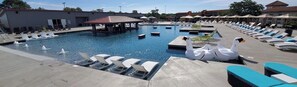 A swimming pool with lounge chairs, a duck float, and a covered area. - Large, Great View, Fully Furnished, Luxury 3bd 2 bath Lake of the Ozarks condo (Lake Ozark)