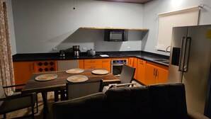 A compact kitchen with a dining table, chairs, a microwave, oven, and a refrigerator. - House With a Private Pool (Ciudad Cortés)
