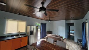 A modern kitchen with a wooden ceiling, a dining area, and a living space with a sofa and a TV. - House With a Private Pool (Ciudad Cortés)