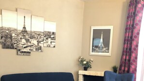 A living room with a sofa, armchair, and a coffee table. - Luxury apartment line 14 IGR Paul Brousse Paris (Villejuif)