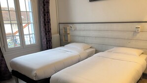 A room with two single beds, a radiator, a window with curtains, and a wall-mounted light fixture. - Luxury apartment line 14 IGR Paul Brousse Paris (Villejuif)
