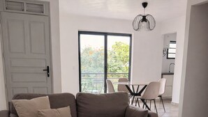 Ein modernes Wohnzimmer mit einer Couch, einem Couchtisch und Blick ins Freie.