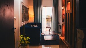 Un salon moderne avec un canapé, une table basse et une vue sur l’extérieur par une fenêtre.