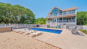 A two-story house with a swimming pool, lounge chairs, and a covered patio area. - JL #034 - Solitude House - Oceanside - Private Pool - Hot Tub (Southern Shores)