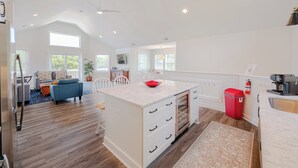 A spacious kitchen with a marble island, white cabinetry, and a red fire extinguisher. - JL #034 - Solitude House - Oceanside - Private Pool - Hot Tub (Southern Shores)