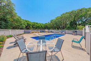 A backyard with a swimming pool, lounge chairs, a table, and a barbecue area. - JL #034 - Solitude House - Oceanside - Private Pool - Hot Tub (Southern Shores)