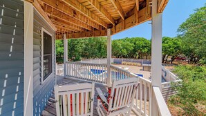 A covered outdoor deck with a pool, white railings, and a view of trees. - JL #034 - Solitude House - Oceanside - Private Pool - Hot Tub (Southern Shores)