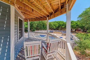 A covered outdoor deck with a pool, white railings, and a view of trees. - JL #034 - Solitude House - Oceanside - Private Pool - Hot Tub (Southern Shores)