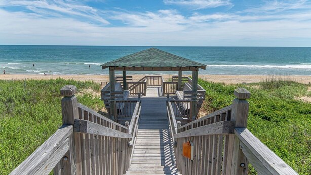 A wooden boardwalk leading to a gazebo on a beach with the ocean in the background. - JL #R-10 | The Regency Condominium | Oceanfront | Community Pool (Kill Devil Hills)