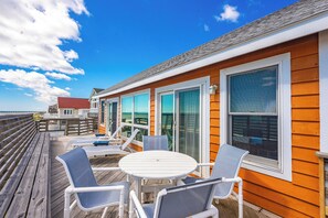 A wooden deck with outdoor furniture, large windows, and a view of the ocean. - JL #228 | Tengerhaz | Oceanfront | Ocean Views (Duck)