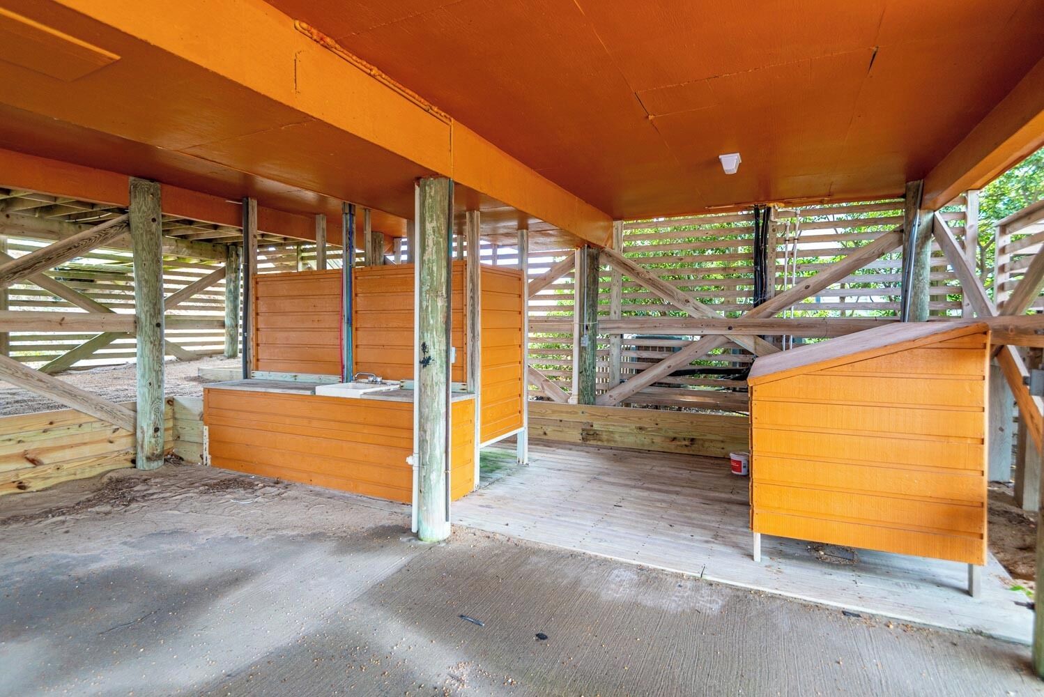A stable with wooden stalls and a concrete floor.