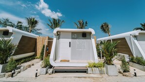 A modern building with a unique architectural design, featuring a prominent entrance with a wooden slatted door and a sign that reads 'SeaSand Seesky.' - Sea Sand See Sky Beach Front Resort (Thep Krasattri)