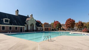 A swimming pool with a brick building in the background.
