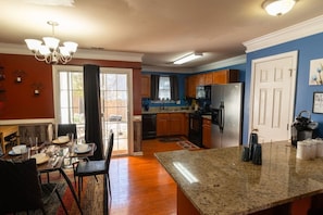 A kitchen with granite countertops, wooden cabinets, and a stainless steel refrigerator. - Gated Atlanta 3BR Gem | Private Community Pool (Atlanta)