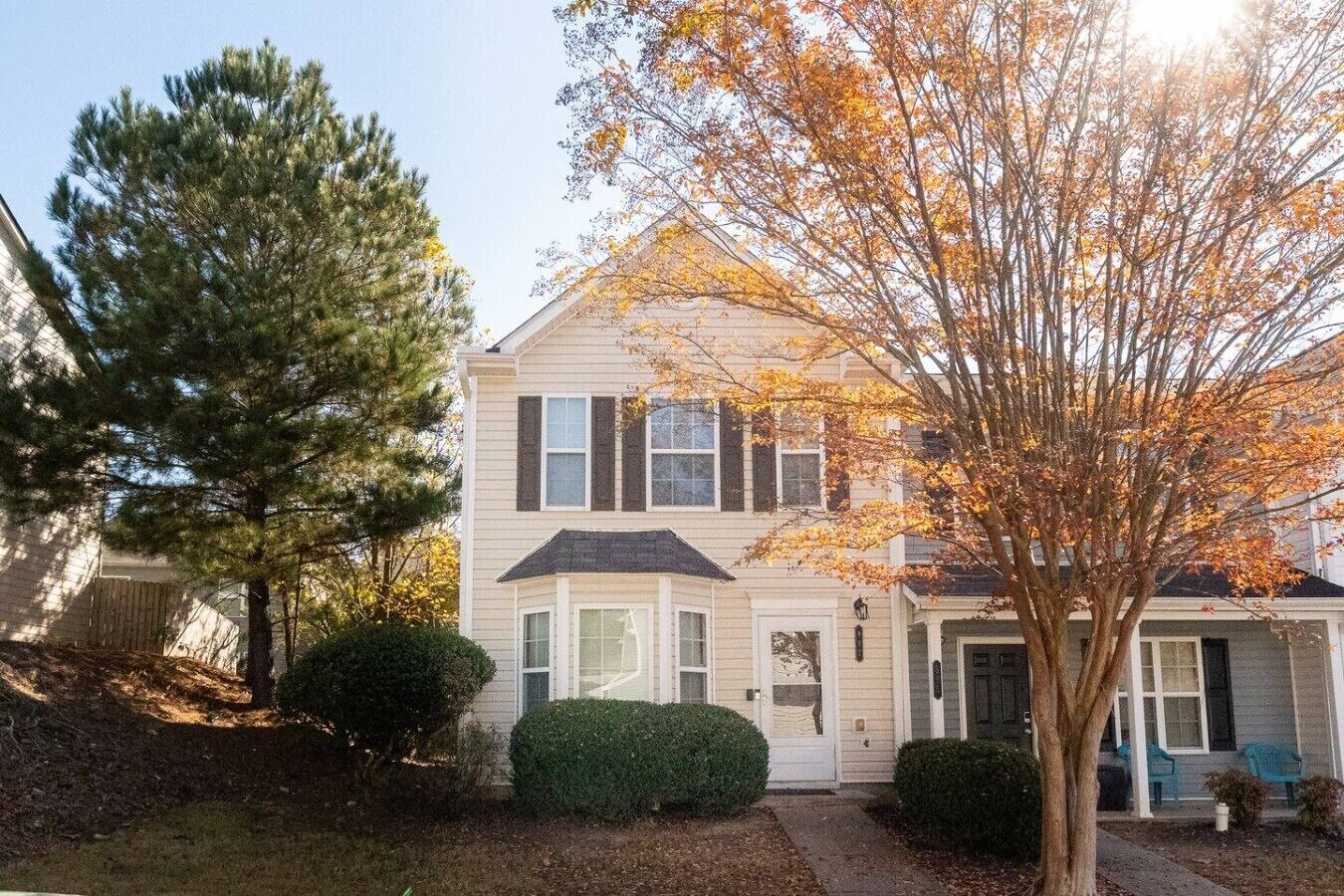A two-story house with a front porch, a garage, and a driveway.