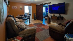 A living room with a TV, sofa, and a dining area. - Downtown Atlanta 3BR Condo • Near Stadium & Arena (Atlanta)