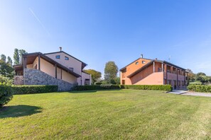 A modern two-story building with a stone facade and a flat roof. - Apartment Experia - Golf & Pool (Castelnuovo del Garda)