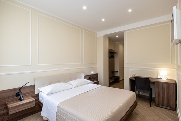 Elegantes und komfortables Doppelzimmer in Verona, modern eingerichtet mit Doppelbett, Schreibtisch und raffinierter Beleuchtung.