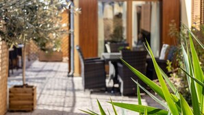 A patio area with outdoor furniture, a table, and a potted plant. - Scaligero Rooms Ida - Tosca - Rigoletto (Verona)