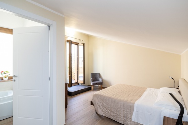 Helles Doppelzimmer der Unterkunft in Verona, das sich durch gemütliche Räume und direkten Zugang nach draußen auszeichnet. Das Zimmer ist modern und funktional eingerichtet und verfügt über ein Doppelbett, eine eigene Beleuchtung und einen Entspannungsbereich, ideal für einen komfortablen und unabhängigen Aufenthalt.