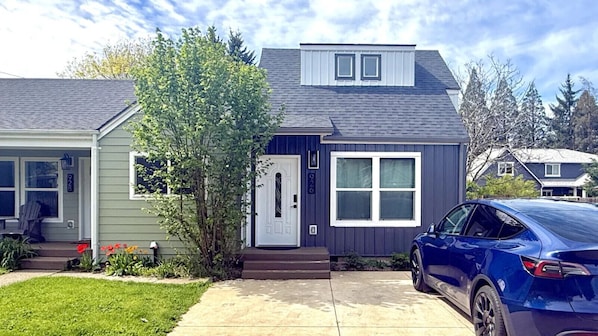 A residential house with a front porch, a garage, and a driveway.