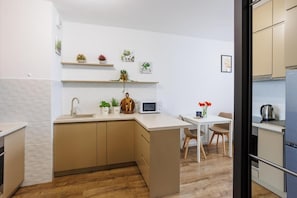 Eine moderne Küche mit einer zentralen Kochinsel, Holzschränken und einem Essbereich mit Tisch und Stühlen.