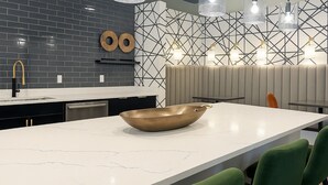 A modern kitchen with a large island, black and white backsplash, and pendant lighting. - Landing | Stunning 1BD, Clubhouse, Gym (Little Rock)