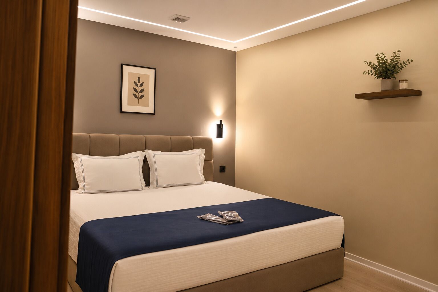 Een slaapkamer met een bed, kussens, een nachtkastje, een wandlamp en een plank met een plant.