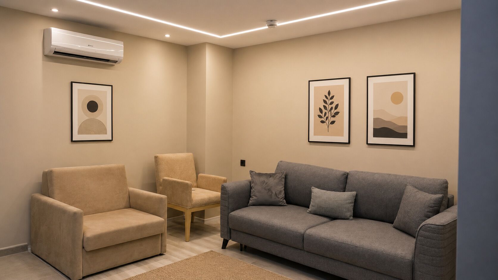 A modern living room with a beige sofa, a grey sofa, and a beige armchair. There are two framed artworks on the wall.