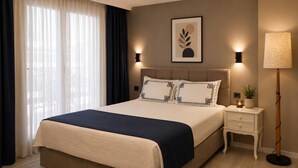 Una habitación de hotel con una cama, mesitas de noche, una lámpara y un cuadro en la pared.