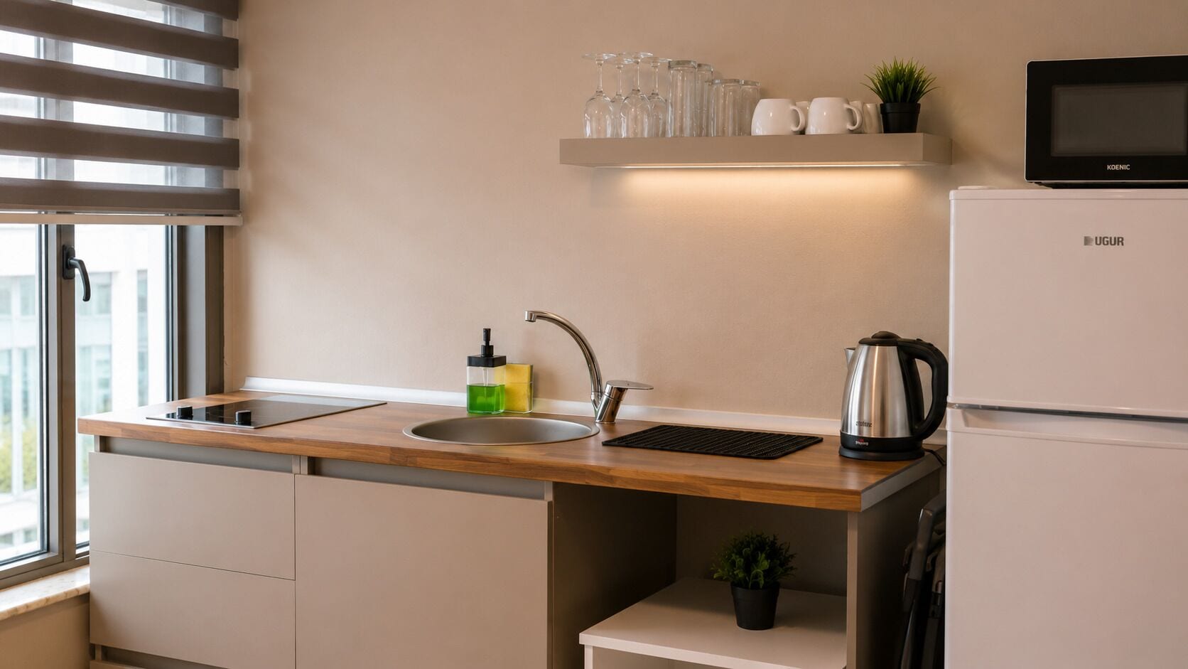 Een moderne keuken met een inbouwspoelbak, waterkoker en magnetron.